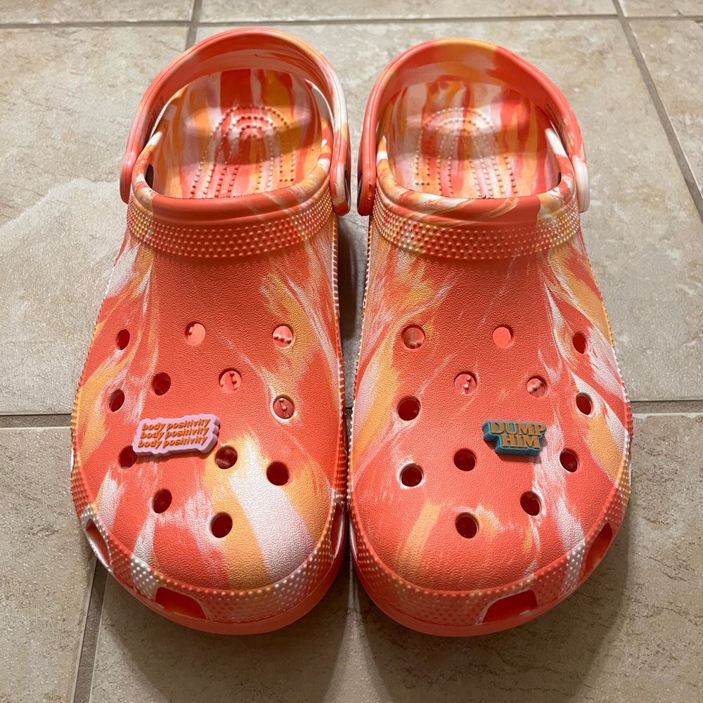 A pair of brand new Crocs with two Jibbitz included.